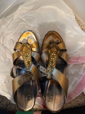 Women's Metallic Gold T-Strap Sandals with Green Stone Detail
